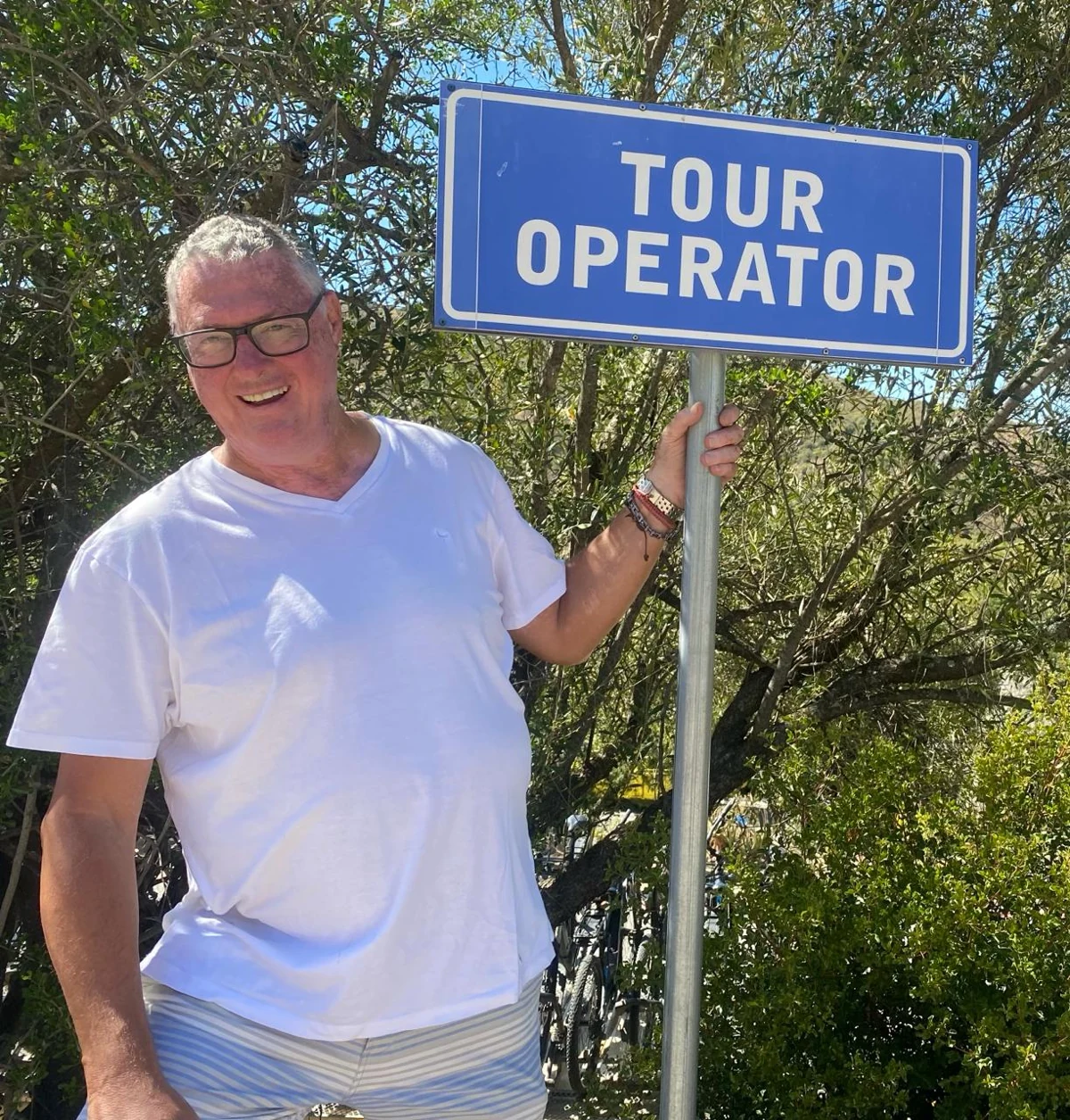 Mike Catton outdoors beside a Tour Operator sign